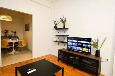 a living room with a television and a table at Ilysia's Retreat, Cozy 1 BDRM Apartment in Athens
