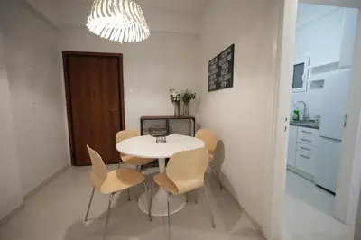 a table and chairs in a kitchen with a chandelier at Ilysia's Retreat, Cozy 1 BDRM Apartment in Athens