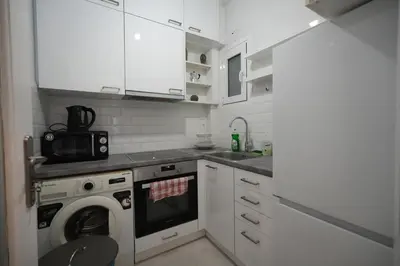 a white kitchen with a washing machine in it at Ilysia's Retreat, Cozy 1 BDRM Apartment in Athens