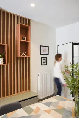 a woman is walking in a room with a striped wall at The Athens Urban Loft in Athens