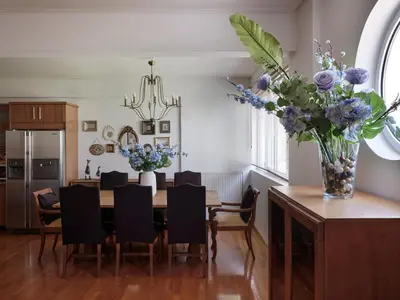 a dining room with a table and a vase of flowers at Evi's Voula Home in Athens
