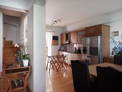 a kitchen and living room with a table and a dining room at Evi's Voula Home in Athens