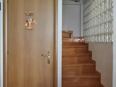 a wooden door with a picture on it next to a staircase at Evi's Voula Home in Athens