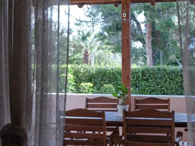 a table and chairs with a table and a window at Evi's Voula Home in Athens