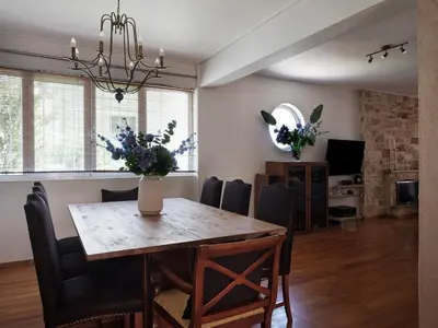 a dining room with a table and chairs with flowers on it at Evi's Voula Home in Athens