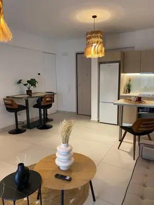 a kitchen and living room with a vase on a table at The Twin Residences in Kallithea in Athens