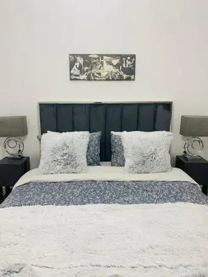 a bedroom with a large bed with blue and white sheets at The Twin Residences in Kallithea in Athens