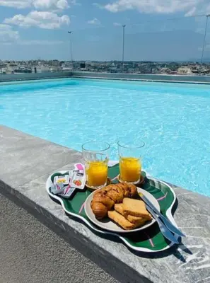 a tray of food and drinks next to a swimming pool at The Twin Residences in Kallithea in Athens