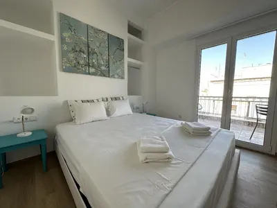a white bedroom with a large bed with towels on it at 6th Floor Skyline Suite with Spectacular View in Athens
