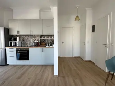 an empty kitchen with white cabinets and a dining room at 6th Floor Skyline Suite with Spectacular View in Athens