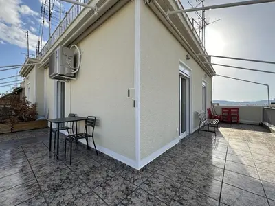 a balcony with chairs and a table on a building at 6th Floor Skyline Suite with Spectacular View in Athens