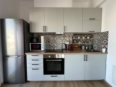 a kitchen with white cabinets and a stainless steel refrigerator at 6th Floor Skyline View Studio 1 in Athens in Athens