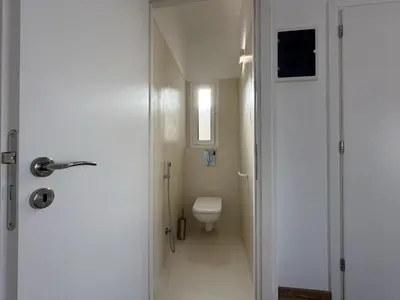 a white bathroom with a toilet and a door at 6th Floor Skyline View Studio 1 in Athens in Athens