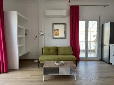 a living room with a green couch and a table at 6th Floor Skyline View Studio 1 in Athens in Athens