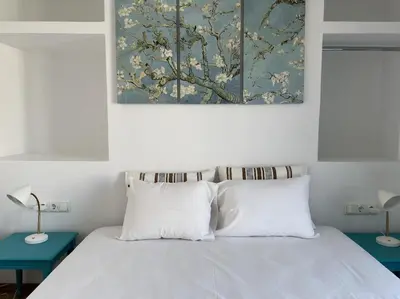 a bed with two pillows and a painting above it at 6th Floor Skyline View Studio 2 in Athens in Athens