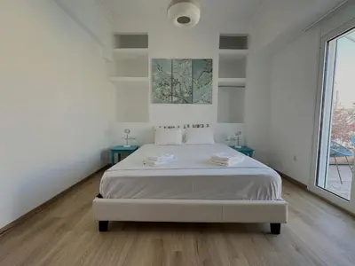 a white bedroom with a bed and a large window at 6th Floor Skyline View Studio 2 in Athens in Athens