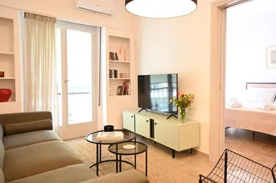 a living room with a couch and a television at Brand new 3bedroom athenian flat in Koukaki in Athens