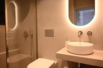a bathroom with a sink and a toilet and a mirror at Brand new 3bedroom athenian flat in Koukaki in Athens