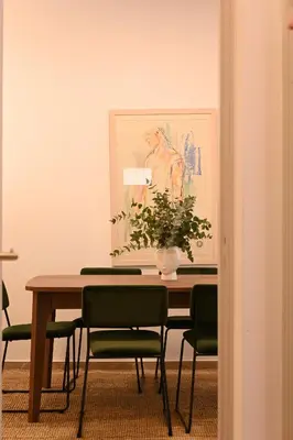 a dining room table with chairs and a painting on the wall at Brand new 3bedroom athenian flat in Koukaki in Athens