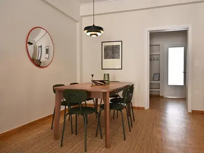 a dining room table with green chairs and a mirror at Pristine 3 bedroom Luxury Sanctuary! in Athens
