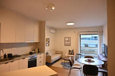 a kitchen and living room with a table and a couch at Luxury Sanctuary- Amazing Sea View - Beach Access in Athens