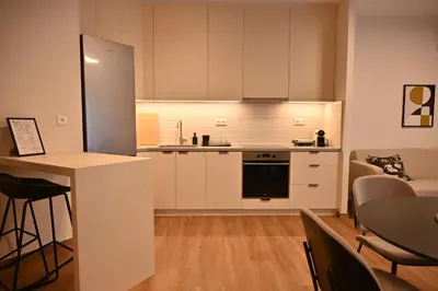 a kitchen with white cabinets and a table in a room at Luxury Sanctuary- Amazing Sea View - Beach Access in Athens