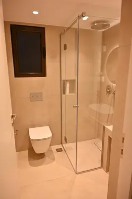 a bathroom with a toilet and a glass shower at Luxury Sanctuary- Amazing Sea View - Beach Access in Athens