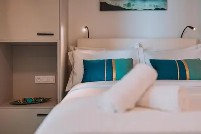 a bedroom with a white bed with blue pillows at Elegant Intimate Studio in Piraeus near Pasalimani in Piraeus