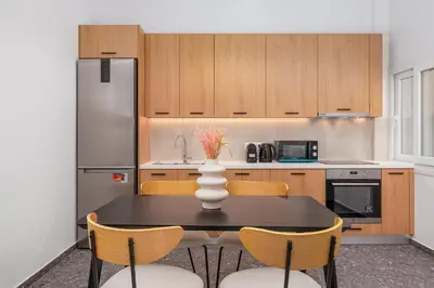 a kitchen with a table with chairs and a refrigerator at Elegant Intimate Studio in Piraeus near Pasalimani in Piraeus