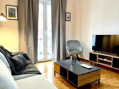a living room with a couch and a tv at Cozy apartment in Athens in Athens