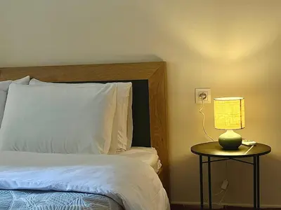 a bedroom with a bed and a lamp on a table at Cozy apartment in Athens in Athens