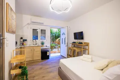 a bedroom with a bed and a kitchen with a sink at Aiolos Lux and Easy suite near the sea alimos in Athens