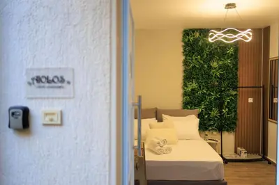 a bedroom with a bed with a green wall at Aiolos Lux and Easy suite near the sea alimos in Athens