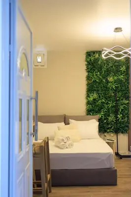 a bedroom with a bed with a green wall at Aiolos Lux and Easy suite near the sea alimos in Athens