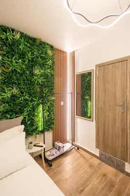 a bedroom with a large green wall at Aiolos Lux and Easy suite near the sea alimos in Athens