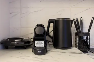a cell phone sitting on a counter next to a coffee pot at Aiolos Lux and Easy suite near the sea alimos in Athens