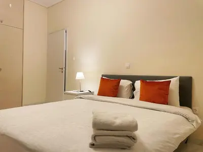a bedroom with a large bed with orange and white pillows at Bluebay comfort apartment Paleo Faliro in Athens