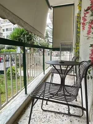 a table and a bench on a balcony at Bluebay comfort apartment Paleo Faliro in Athens