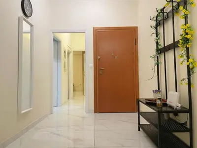 a hallway with a door and a table with flowers at Bluebay comfort apartment Paleo Faliro in Athens