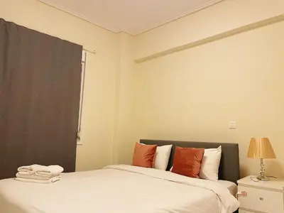 a bedroom with a bed with orange and white pillows at Bluebay comfort apartment Paleo Faliro in Athens