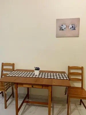 a wooden table with two chairs and a table with aussion at Bluebay comfort apartment Paleo Faliro in Athens
