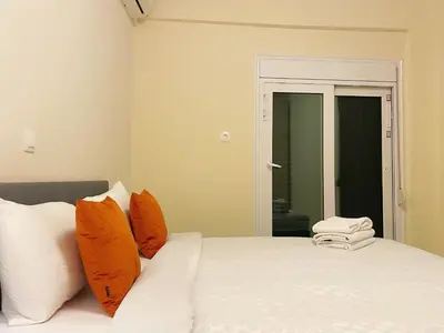a bedroom with a bed with orange and white pillows at Bluebay comfort apartment Paleo Faliro in Athens