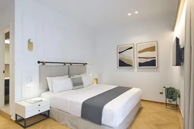 a white bedroom with a large white bed in it at The Athenian Chic Elegant Apartments in Kolonaki in Athens