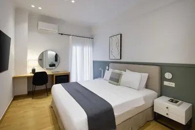 a bedroom with a bed and a desk with a mirror at The Athenian Chic Elegant Apartments in Kolonaki in Athens