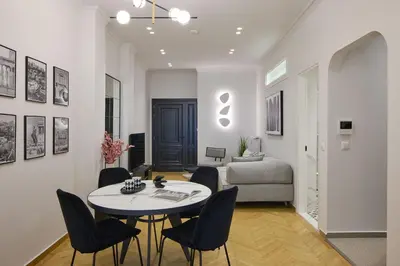 a living room with a table and chairs and a bed at The Athenian Chic Elegant Apartments in Kolonaki in Athens
