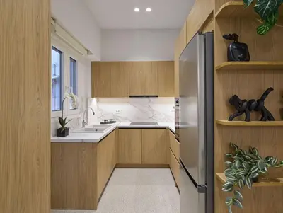 a kitchen with wooden cabinets and a stainless steel refrigerator at The Athenian Chic Elegant Apartments in Kolonaki in Athens