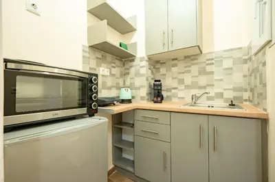 a small kitchen with a microwave and a sink at Gyzi Center Studio by MPS in Athens