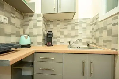 a kitchen with white cabinets and a sink at Gyzi Center Studio by MPS in Athens