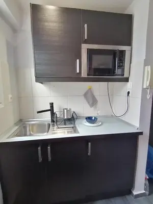 a small kitchen with a sink and a microwave at Penthouse! Best views Lycabetous & Parthenon ! EXARCHEIA in Athens