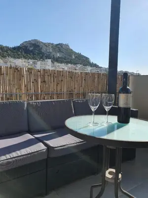 a table with two wine glasses on a patio at Penthouse! Best views Lycabetous & Parthenon ! EXARCHEIA in Athens